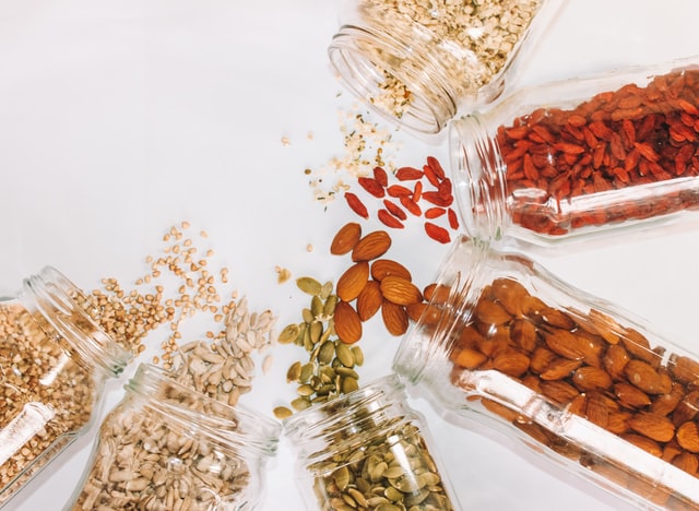  Almonds, pumpkin seeds and other nuts spilling out of jars