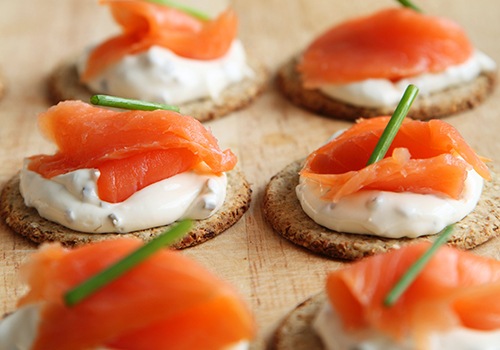  Cured salmon with creme fraiche and chives on crackers.
