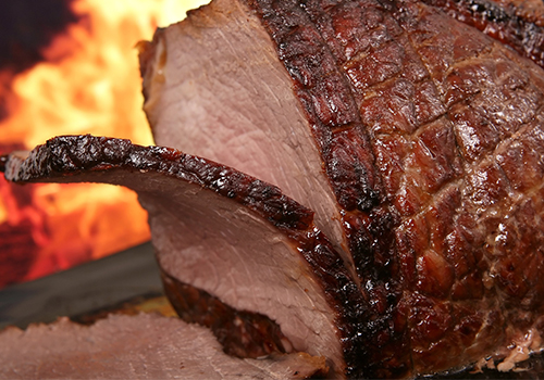  Close up of roast lamb leg being sliced.