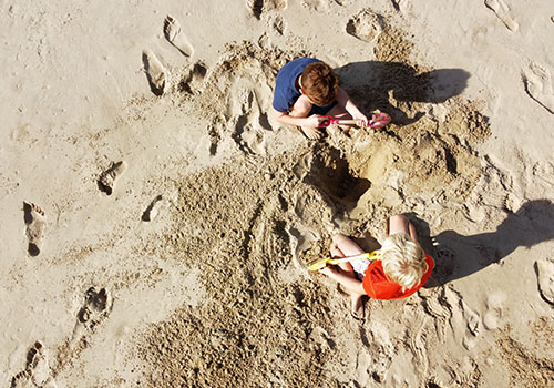 Kids digging a pool on the beach