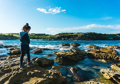 Child exploring rock pools 