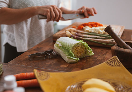 Woman chopping cabbage in kitchen