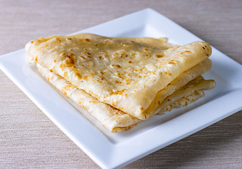 Folded up roti on a plate